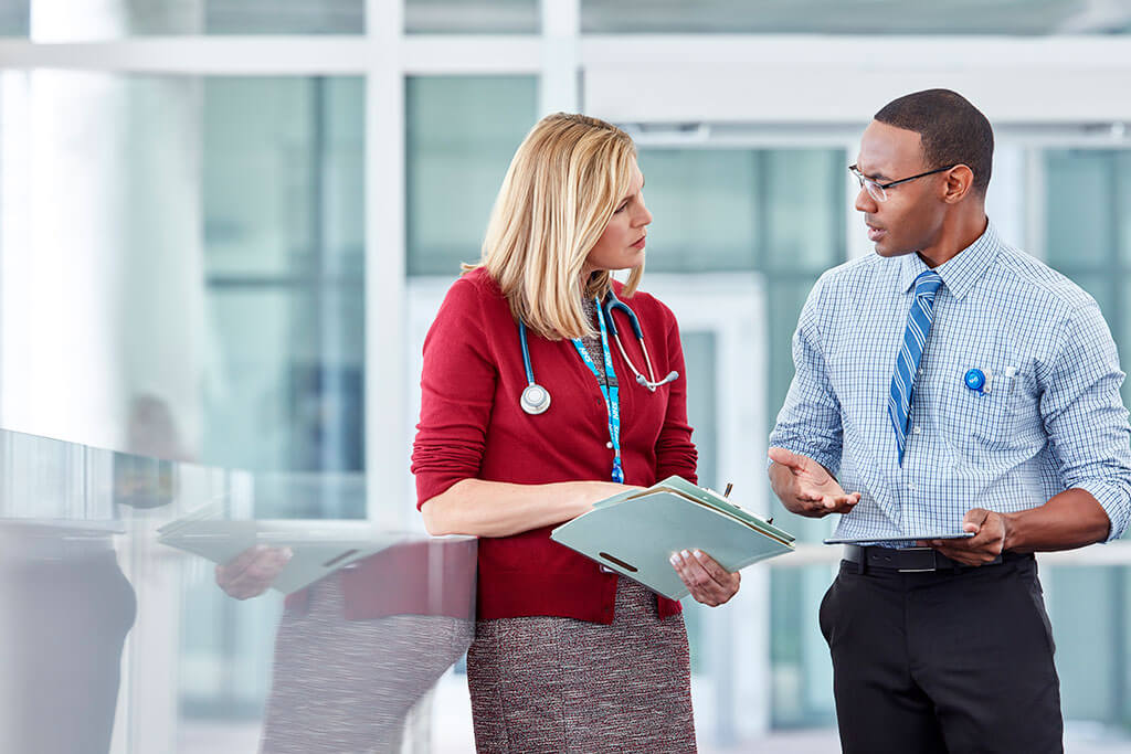 NHS doctor discussing information with colleague