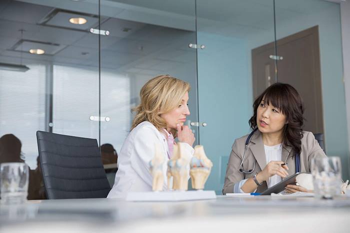 female medical professionals reviewing information on tablet