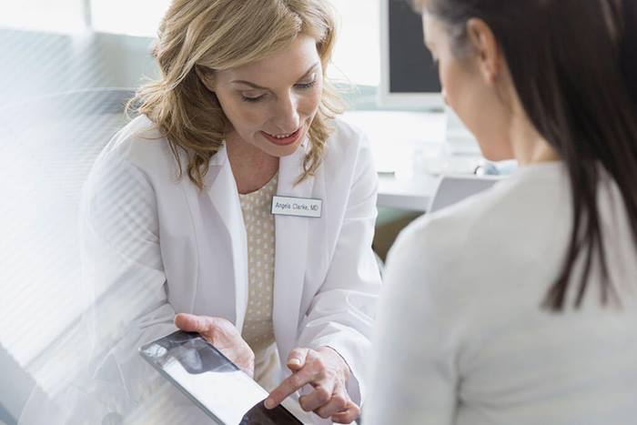 doctor showing info to patient on tablet