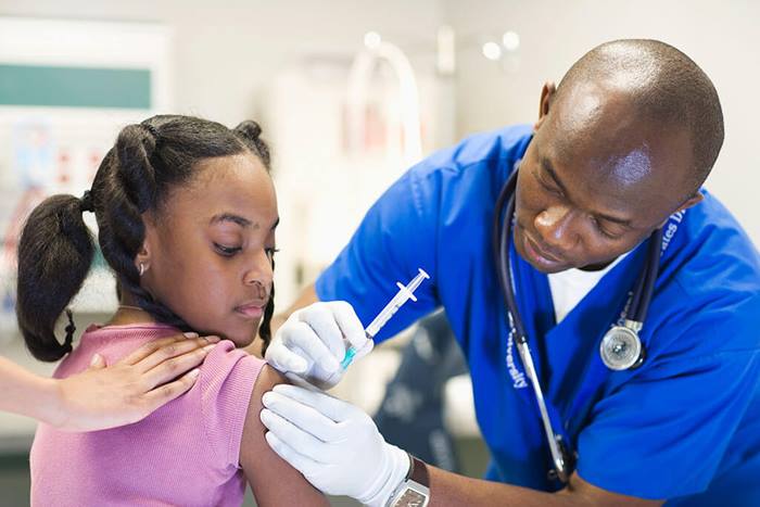 male nurse giving young patient injection
