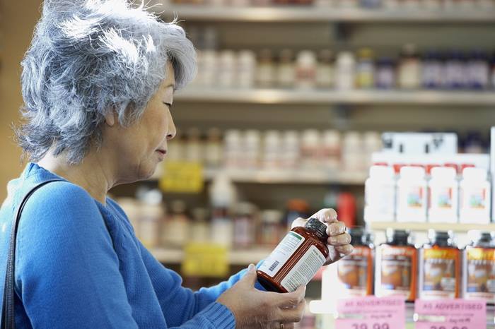 senior asian woman reading label