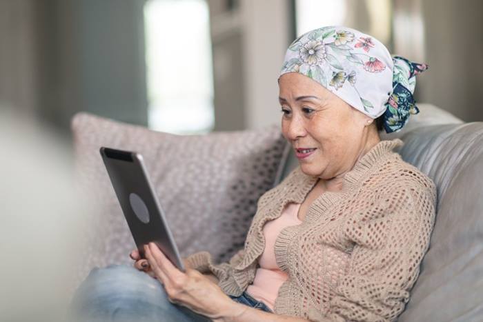woman with cancer tablet at home