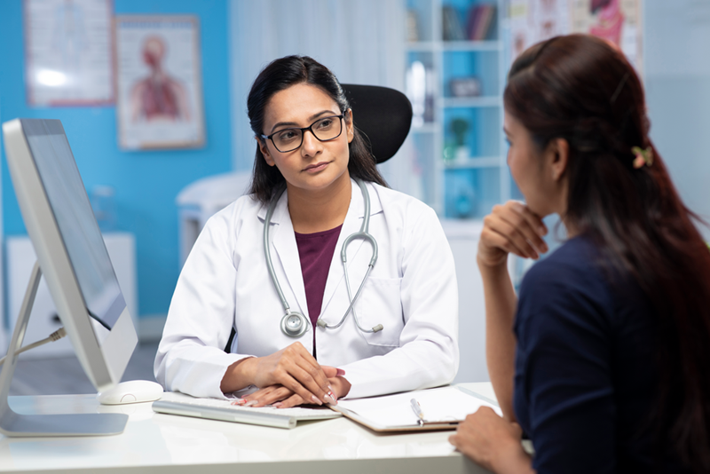 1145_Doctor and patient are discussing at clinic and writing Prescription Medicine