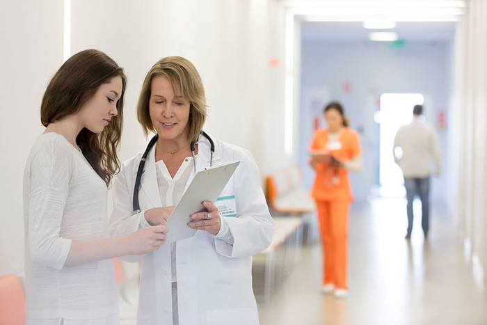 Doctor reviewing information on clipboard with patient