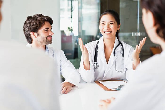 Doctor talking to colleagues in meeting