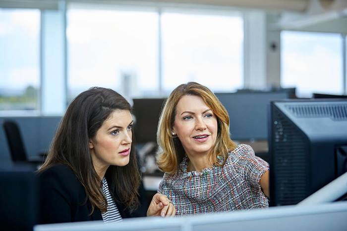 Businesswomen discussing over computer at their desk