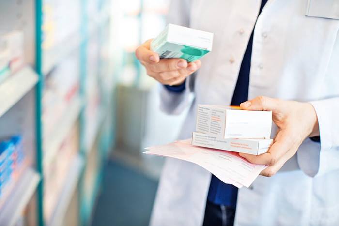 pharmacists hands taking medicines from shelf