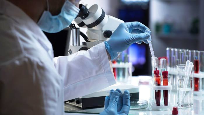 Laboratory assistant taking drop of blood