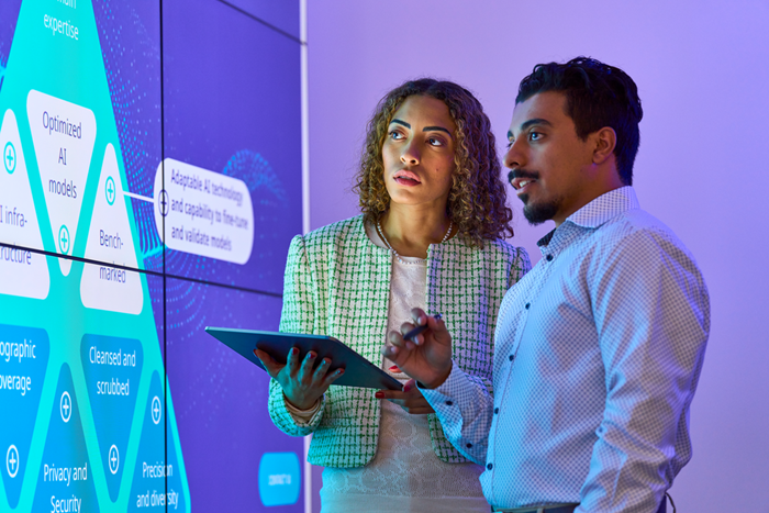 Custom Photo Two people looking at data on screens holding tablet