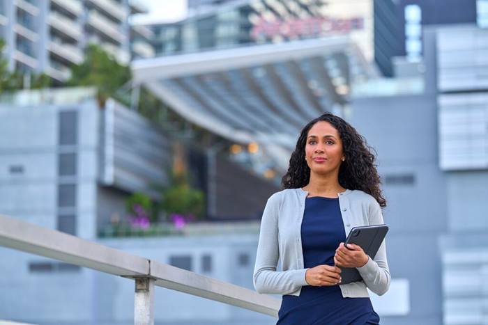 Female executive being thoughtful in a cityscape holding tablet