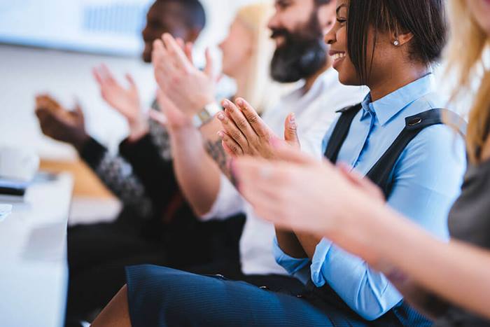 group of people clapping in a conference hall