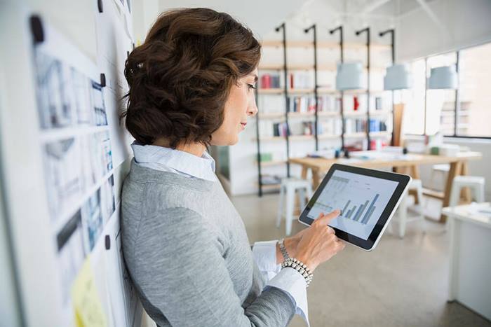 female viewing bar graph tablet in office