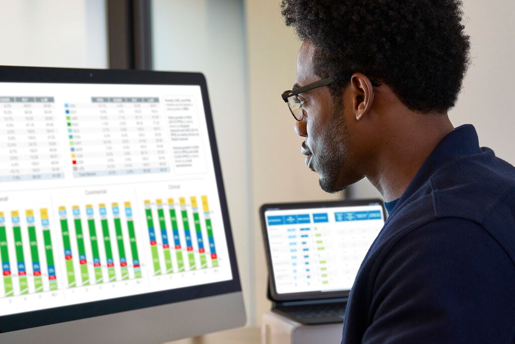Man analyzing BrandImpact score metrics on screen for promotional effectiveness insights.