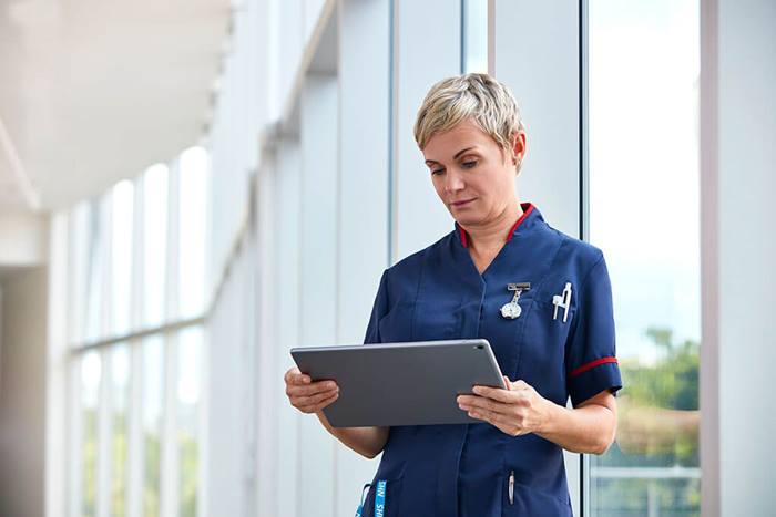 NHS nurse looking at tablet information