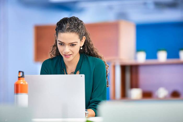 professional female typing on her laptop