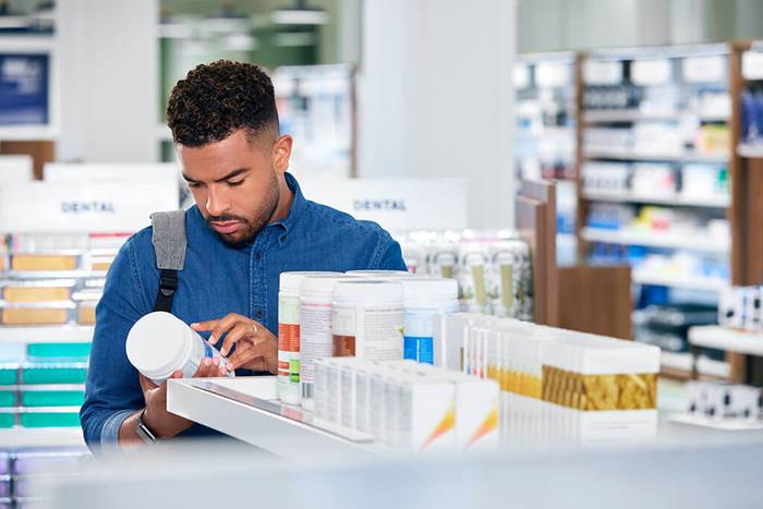 male pharmacy customer studying nutritional product