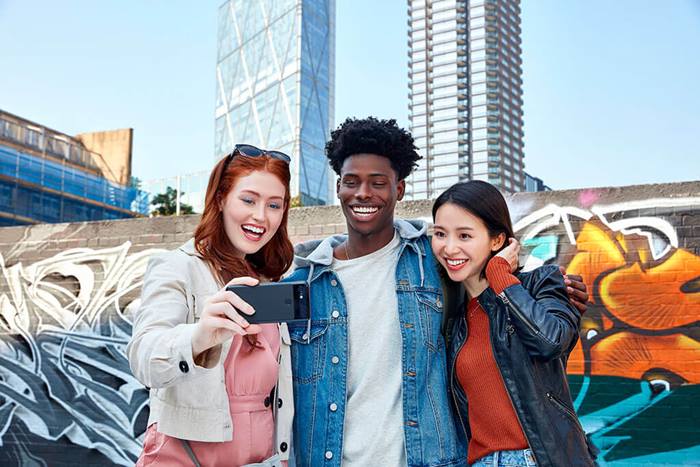 3 friends taking a selfie graffiti wall and city