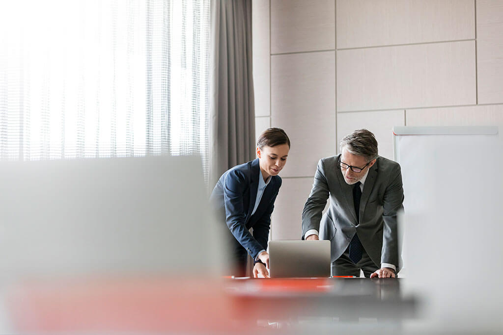 893_Businessman and businesswoman using laptop in conference room﻿