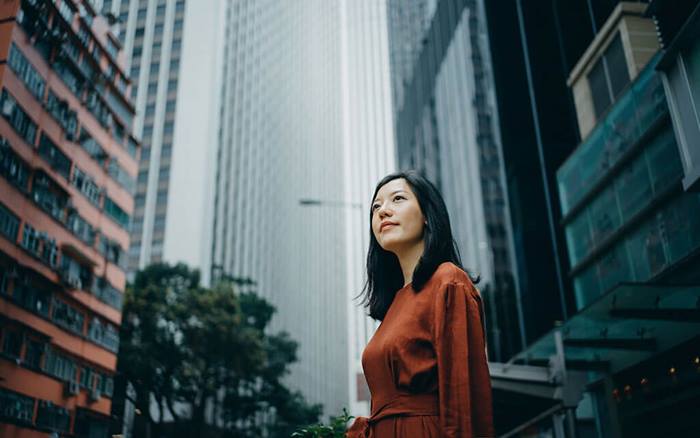 Asian businesswoman standing against highrise city buildings