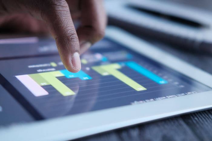 close up of male hand analyzing charts on tablet