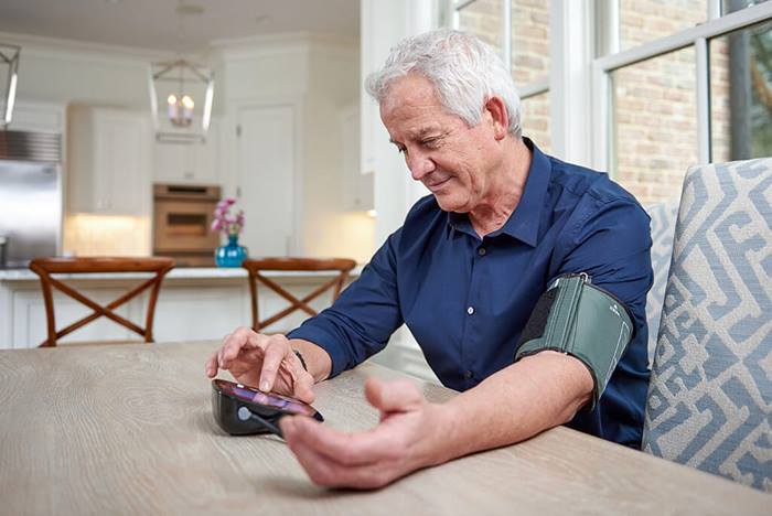 Elderly man checking his blood pressure