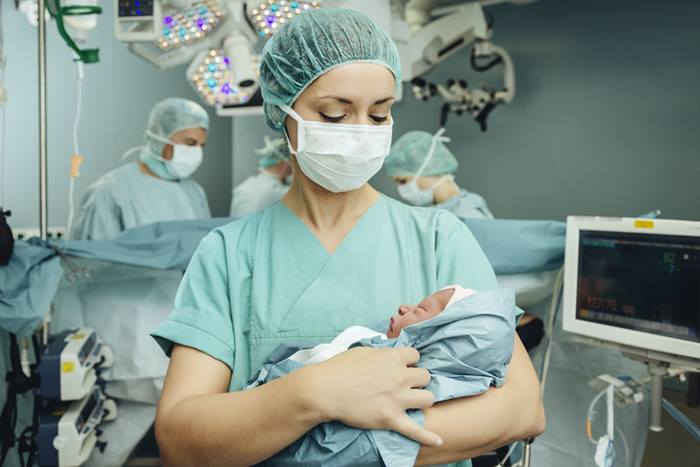 Nurse with baby delivery room