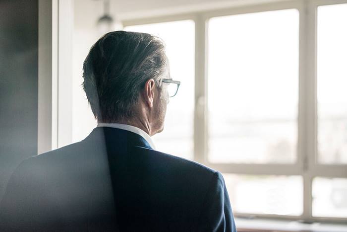 Rear view of mature businessman looking out of window